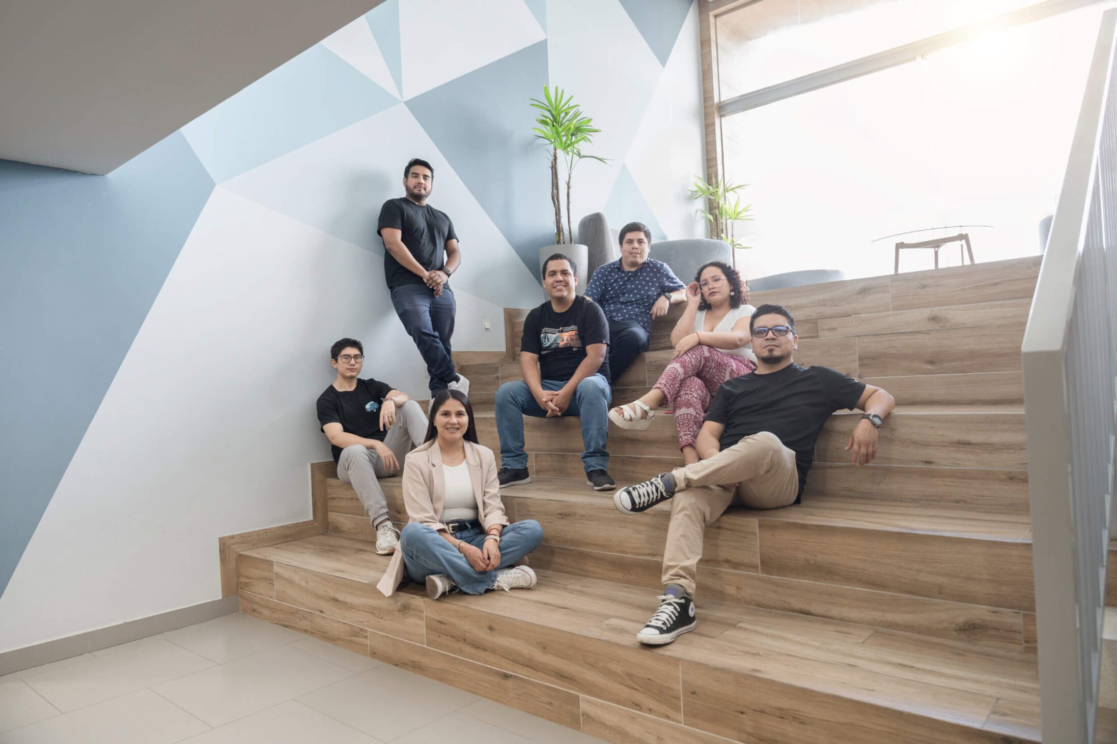 Un grupo de personas de una agencia de diseño web sentadas en las escaleras de una oficina.